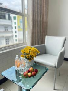 uma mesa com um vaso de flores e frutas sobre ela em Gold hotel, Saigon em Ho Chi Minh