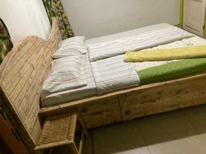 a wooden bed with a chair in a room at Kivu Beach Garden in Gisenyi