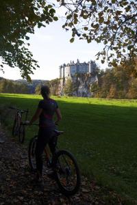 Una donna che va in bicicletta davanti a un castello. di La Bricole a Dinant