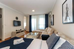 sala de estar con cama y sofá en New Belgrade Apartments, parking 5 eur per day, en Belgrado