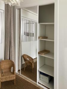 Habitación con silla y estante para libros en F2 cosy central I Rueil-Malmaison I La BonBonniere 92500, en Rueil-Malmaison
