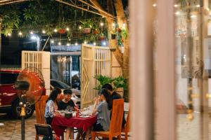 a group of people sitting at a table in a restaurant at Loop Homestay in Thương Xà (2)