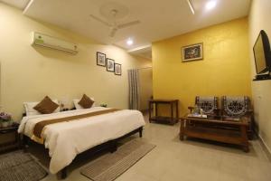 1 dormitorio con 1 cama grande y pared amarilla en Tiger Heaven Resort, en Bandhogarh Fort