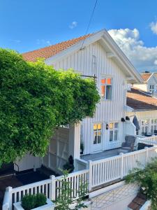 a white house with a white fence at Victoriagården in Grimstad