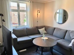 a living room with a couch and a table at Victoriagården in Grimstad