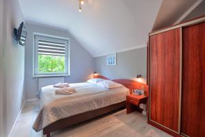 a small bedroom with a bed and a window at Ośrodek Wypoczynkowy Evita in Krynica Zdrój