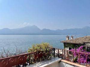 a balcony with a view of the water and a house at Apartment Vista Lake Torri in Torri del Benaco