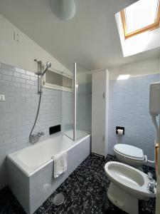a bathroom with a tub and a toilet and a sink at Apartment Vista Lake Torri in Torri del Benaco