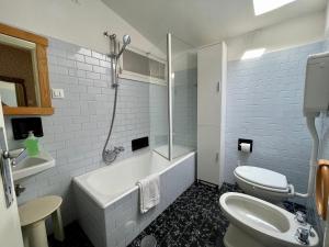 a bathroom with a tub and a toilet and a sink at Apartment Vista Lake Torri in Torri del Benaco