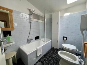 a bathroom with a tub and a toilet and a sink at Apartment Vista Lake Torri in Torri del Benaco +6 photos