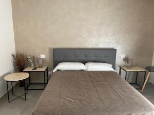 una camera da letto con un grande letto con due tavoli di B&B Campo Sportivo a Taurianova