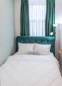 a bed with a green headboard in a bedroom at FIT Apartments in Sarajevo +59 photos
