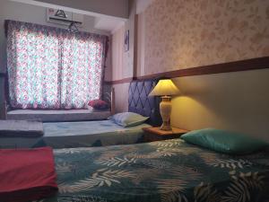 een hotelkamer met 2 bedden en een raam bij Shahmi Seaview Apartment (North) in Port Dickson