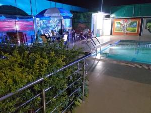 basen ze stołem i parasolem w obiekcie Tiger Heaven Resort w mieście Bandhogarh Fort