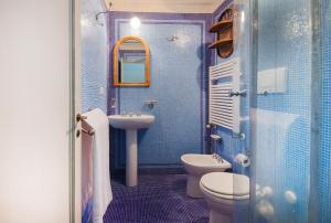 ein blau gefliestes Bad mit WC und Waschbecken in der Unterkunft Apartments Florence- Borgo Pinti with Frescoes in Florenz