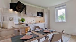 cocina con mesa, sillas y encimera en Haus-zum-Leuchtturm-Whg-02, en Sankt Peter-Ording