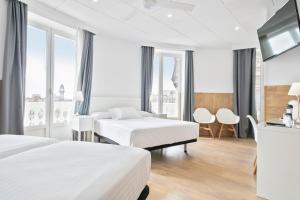 a hotel room with two beds and a flat screen tv at Venecia Plaza Centro in Valencia