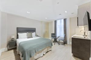 een slaapkamer met een bed en een wastafel in een kamer bij Cleveland Residences Kensington in Londen
