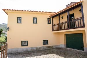 ein Haus mit einer grünen Garagentür in der Unterkunft Casa de São Bernardo by LovelyStay in Lamego