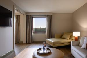 a living room with a couch and a table at Hotel Coimbra Aeminium, Affiliated by Meliá in Coimbra