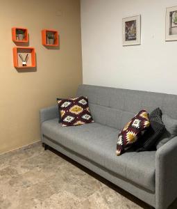 1 sofá gris con 2 almohadas en la sala de estar en Apartamento La Rosa - RECIÉN REFORMADO, en Córdoba