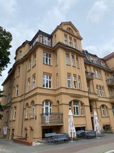 un gran edificio con mesas delante en Apartamenty Słowackiego 16 en Poznan