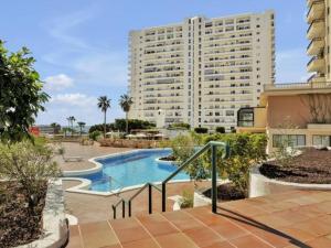 a large building with a swimming pool in front of a building at 212 Elegant, renovated, confortable Playa Paraiso in Playa Paraiso