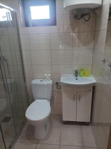 a bathroom with a toilet and a sink and a shower at Domki Afrodyta in Jarosławiec +12 photos