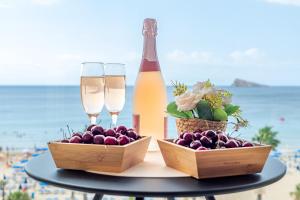 uma mesa com duas taças de champanhe e uma garrafa de vinho em Mucho Gusto Santa Margarita em Benidorm