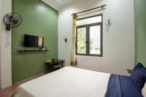 - une chambre avec un lit blanc et une fenêtre dans l'établissement Loop Homestay, à Thương Xà (2)