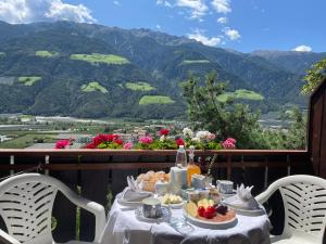 einen Tisch mit Speisen und Bergblick in der Unterkunft Haus Käfersberg in Naturns
