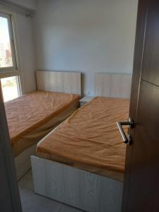 two beds in a small room with a door at Porto golf marina in El Alamein