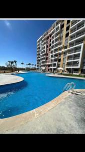a large swimming pool in front of a large building at Porto golf marina in El Alamein