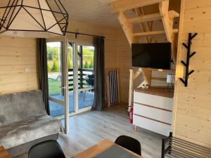 a living room with a couch and a television at DomkiToTu in Jarosławiec