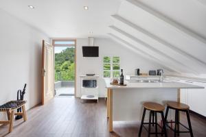 a kitchen with a sink and a counter with stools at Casa da Olides - T3 and Studio in Santana