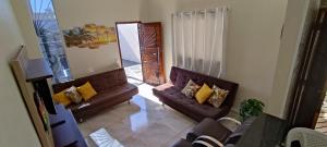 ein Wohnzimmer mit zwei braunen Sofas und einem Spiegel in der Unterkunft A Casa Linda Com Piscina Aquecida churrasqueira wifi pertinho da praia em Itanhaém in Itanhaém