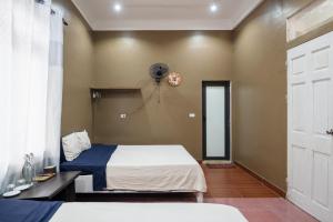 a bedroom with two beds and a window and a door at Loop Homestay in Thương Xà (2)