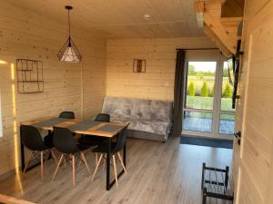 a dining room with a table and chairs and a couch at DomkiToTu in Jarosławiec