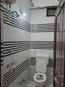 a bathroom with a toilet and black and white stripes at Shree Krishna Hotel in Udaipur