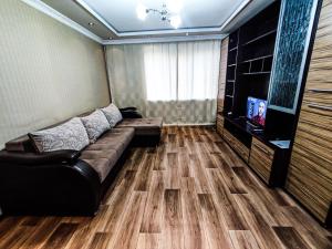 uma sala de estar com um sofá e uma televisão de ecrã plano em Уютная трёхкомнатная квартира em Pavlodar