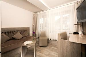 a living room with a couch and a table at Hotel Deutsches Haus in Gifhorn
