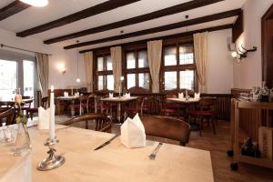 a dining room with tables and chairs and windows at Hotel Deutsches Haus in Gifhorn