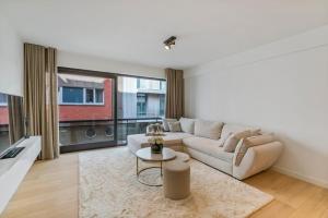 - un salon avec un canapé et une table dans l'établissement Modern appartement in hartje Oostende, à Ostende