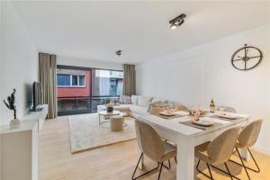 - un salon blanc avec une table et des chaises blanches dans l'établissement Modern appartement in hartje Oostende, à Ostende