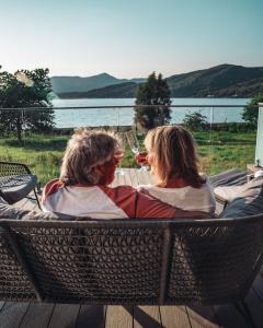 two people sitting in a wicker chair with a glass of wine at SeaBeds - Luxury Lookouts with Hot Tubs in Glencoe