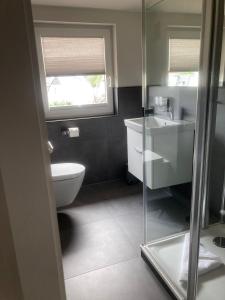 a bathroom with a toilet and a sink and a window at Oasis 07 in Cuxhaven