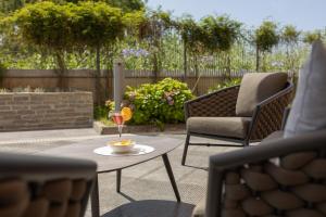 a patio with a table and a glass of wine at Novotel Salerno Est Arechi in Salerno