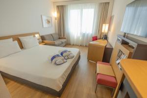 um quarto de hotel com uma cama com duas toalhas em Novotel Salerno Est Arechi em Salerno