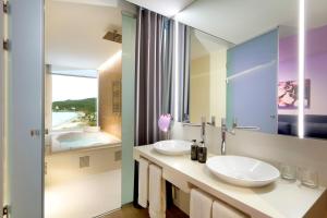 a bathroom with two sinks and a large mirror at Hard Rock Hotel Ibiza in Playa d'en Bossa