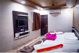 Zimmer mit 3 Betten, Handtüchern und einem TV in der Unterkunft Hotel Qadri 4 Min Distance from Dargah in Ajmer